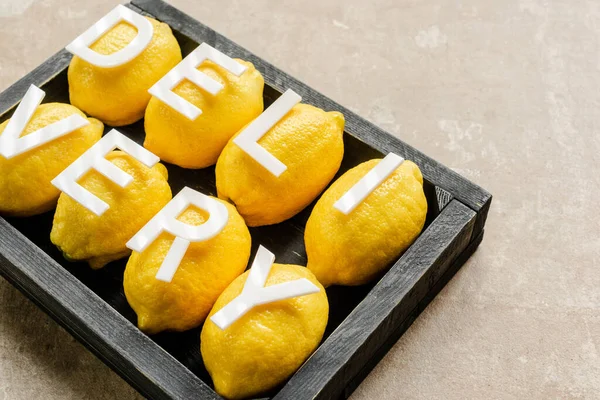 Доставка слова на лимонах у дерев'яній чорній коробці на вивітрюваній поверхні — стокове фото