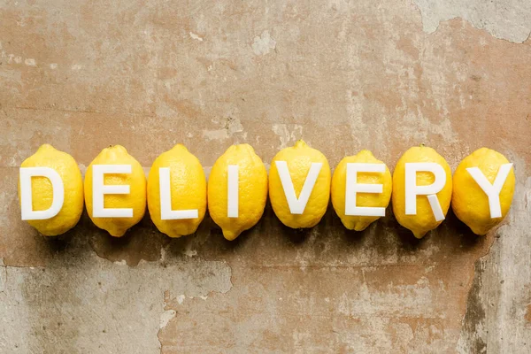 Top view of word delivery on lemons on weathered surface — Stock Photo