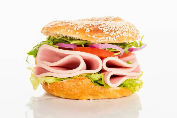 Frischer leckerer Bagel mit Wurstscheiben auf weißem Hintergrund — Stockfoto