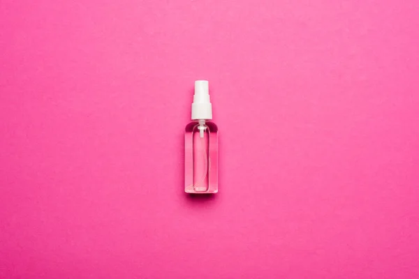 Vista dall'alto del flacone spray trasparente con disinfettante per mani liquide su rosa — Foto stock