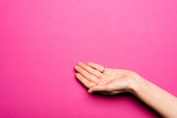 Mano femenina con palma abierta sobre rosa - foto de stock