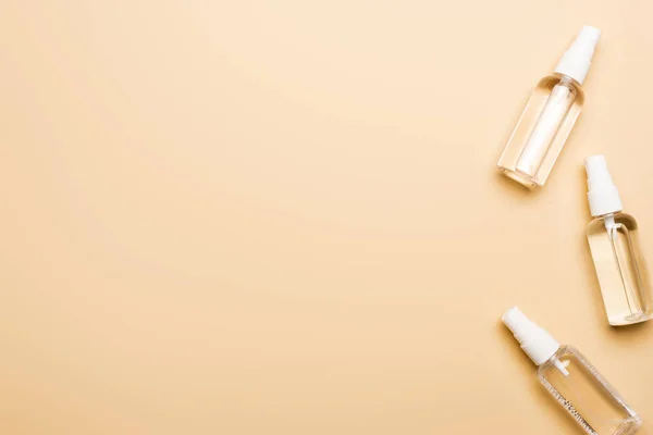 Top view of transparent spray bottles with liquid disifectant on beige — Stock Photo