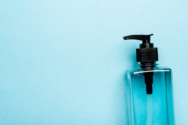 Top view of hand sanitizer in transparent bottle with dispencer on blue — Stock Photo