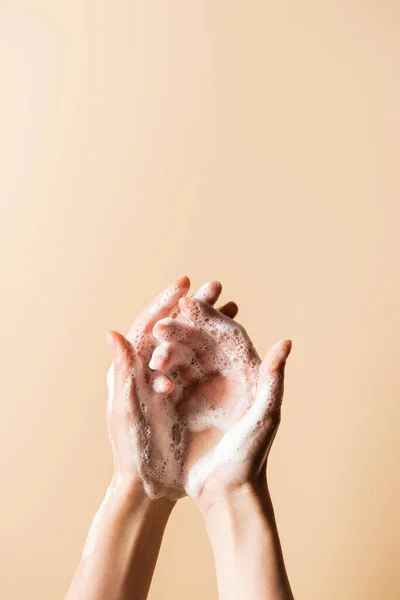 Vista cortada da mulher lavar as mãos com espuma de sabão isolado no bege — Fotografia de Stock