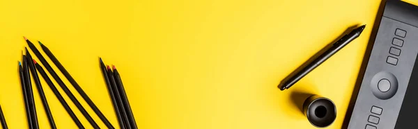 Concepto panorámico de la tableta de dibujo y lápices cerca de lápiz en amarillo - foto de stock