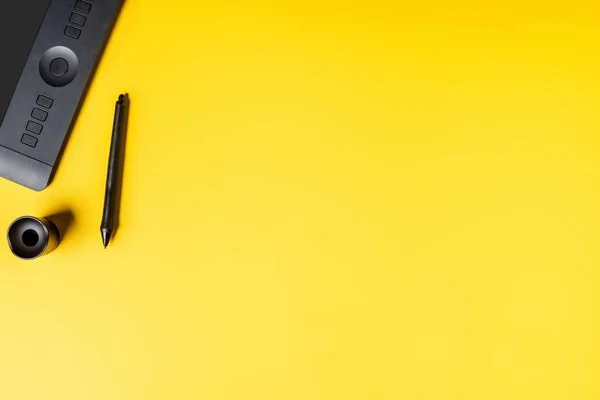 Верхний вид держателя стилуса и рисунок планшета рядом со стилусом на желтом — стоковое фото