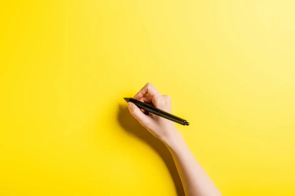 Vista recortada del diseñador sosteniendo lápiz en amarillo - foto de stock