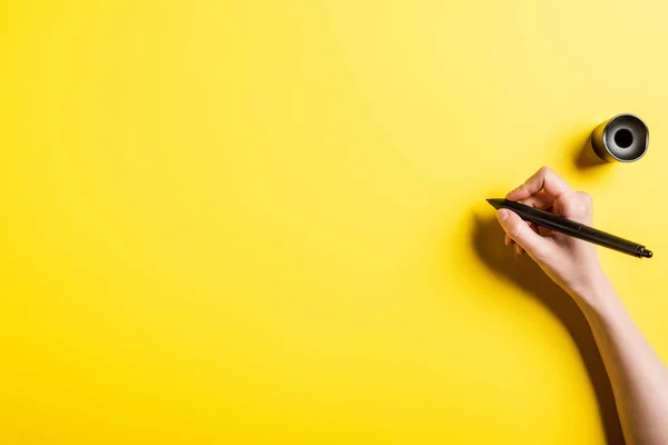 Vista recortada del diseñador sosteniendo lápiz en la mano en amarillo - foto de stock