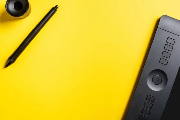 Top view of modern drawing tablet, stylus and holder on yellow — Stock Photo