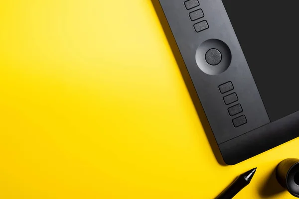 Vista superior do tablet desenho moderno e estilete preto no amarelo — Fotografia de Stock