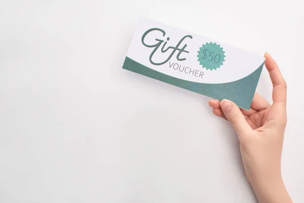 Top view of woman holding gift voucher with 50 dollars sign on white background — Stock Photo