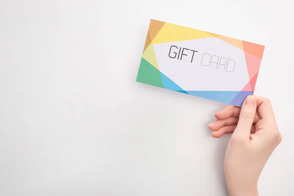 Top view of woman holding gift card on white background — Stock Photo