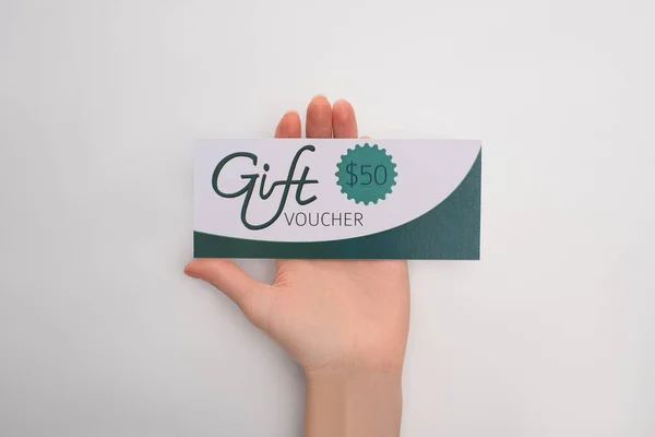 Cropped view of woman holding gift voucher with 50 dollars sign on white background — Stock Photo