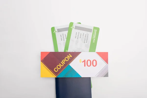 Vue du dessus du coupon avec 100 dollars chantent sur le passeport avec des billets d'avion sur fond blanc — Photo de stock