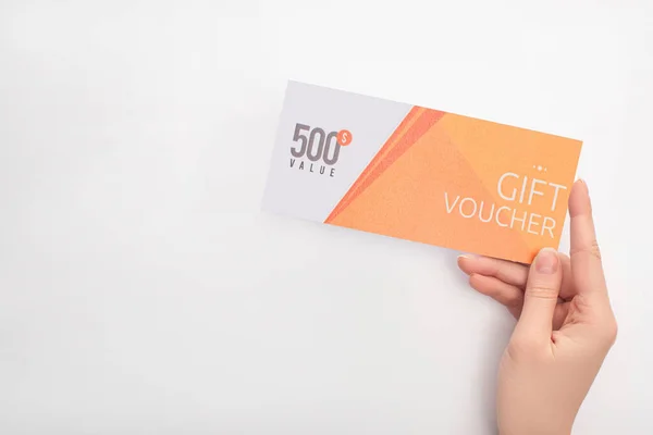 Cropped view of woman holding gift voucher with 500 value lettering on white background — Stock Photo
