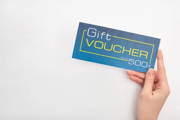 Visão superior da mulher segurando voucher presente azul com valor e sinal de dólar no fundo branco — Fotografia de Stock