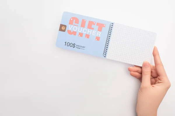 Vista superior de la mujer que sostiene el cupón de regalo con 100 dólares de descuento en fondo blanco - foto de stock