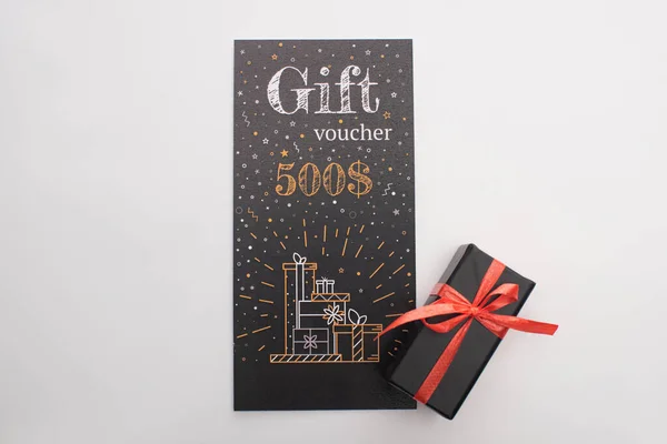 Draufsicht auf Geschenkgutschein und Geschenkbox mit Band auf weißem Hintergrund — Stockfoto