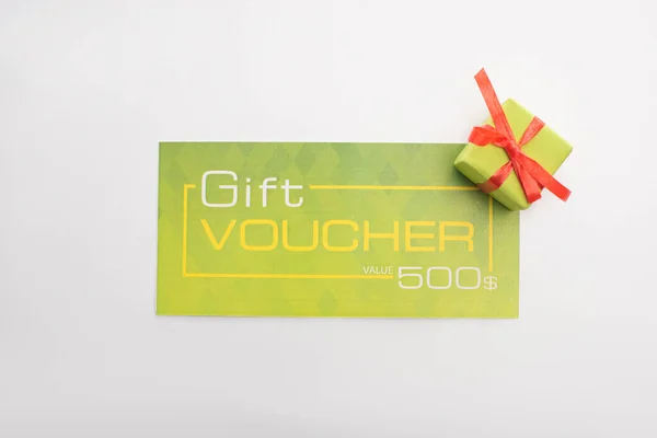 Top view of green gift voucher with gift box isolated on white — Stock Photo