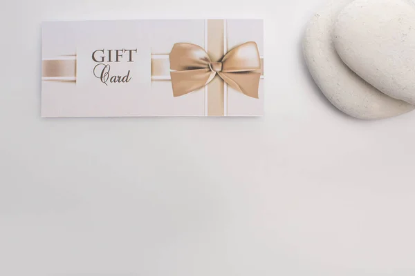 Top view of gift card near zen stones on white background — Stock Photo