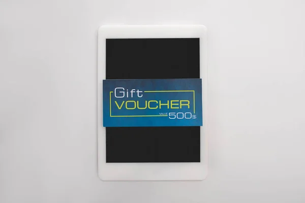 Ansicht von Geschenkgutschein auf digitalem Tablet auf weißem Hintergrund — Stockfoto