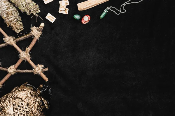 Top view of runes and amulets near crystals and voodoo skull on black — Stock Photo