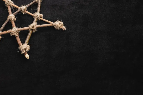 Top view of pentagram with wooden sticks on black — Stock Photo