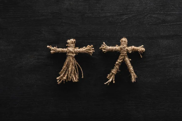 Top view of creepy voodoo dolls on black — Stock Photo