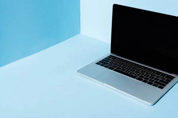 Modern laptop with blank screen on blue background — Stock Photo