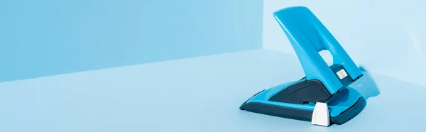 Perforatore blu foro di plastica su sfondo blu, colpo panoramico — Foto stock