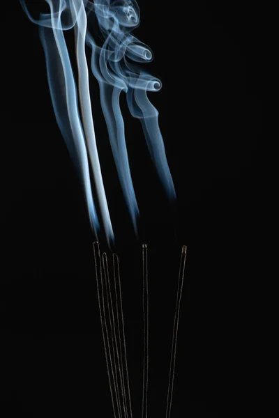 Brennende Aromastäbe mit Rauch auf schwarzem Hintergrund — Stockfoto