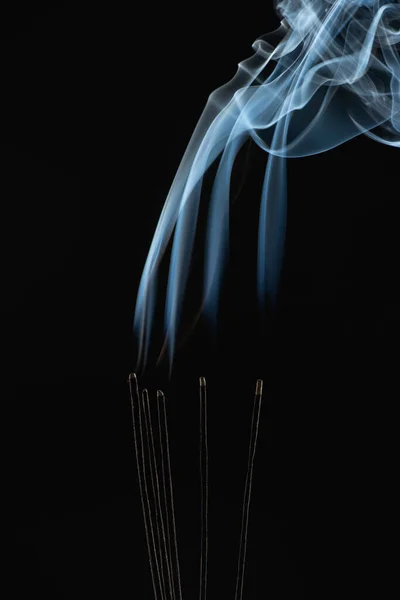 Brennende Aromastäbe mit Rauch auf schwarzem Hintergrund — Stockfoto