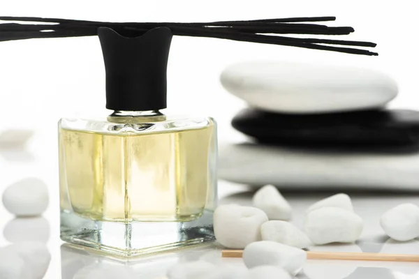 Enfoque selectivo de palos de aroma y perfume cerca de piedras de spa aisladas en blanco - foto de stock