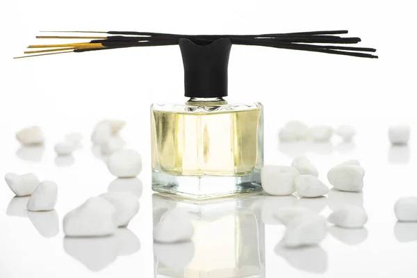 Enfoque selectivo de palos de aroma y perfume cerca de piedras aisladas en blanco - foto de stock