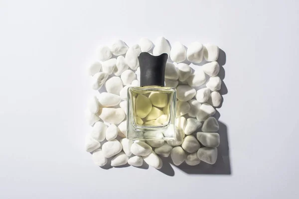 Top view of home perfume in bottle on square made of stones on white background — Stock Photo