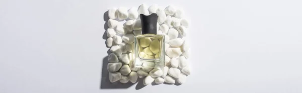 Top view of home perfume in bottle on square made of stones on white background, panoramic shot — Stock Photo