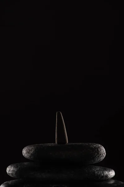 Incense cone on stones isolated on black background — Stock Photo