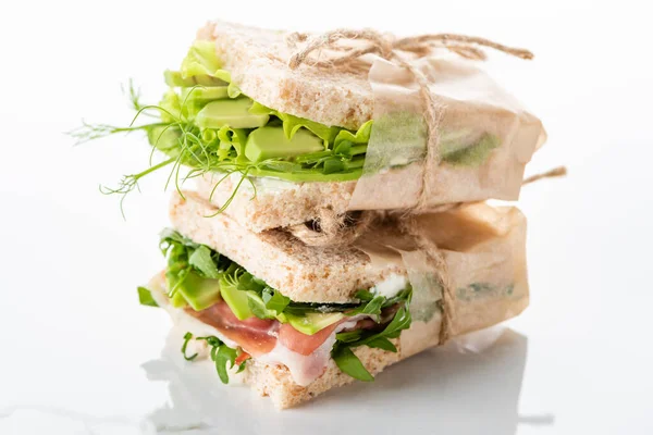 Fresh green sandwiches with avocado and jamon on marble white surface — Stock Photo