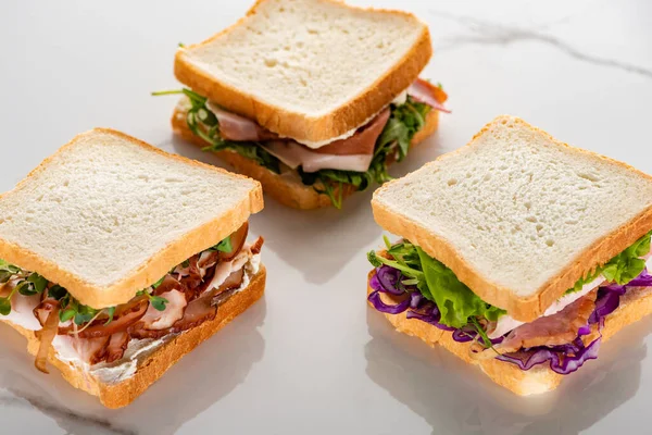 Fresh green sandwiches with meat on marble white surface — Stock Photo