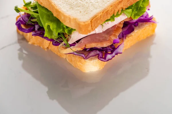 Close up view of fresh green sandwich with meat on marble white surface — Stock Photo