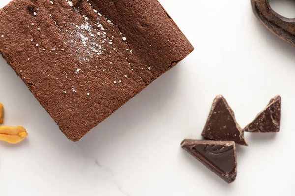 Vue du dessus de délicieux morceau de brownie près de chocolat sur fond blanc — Photo de stock