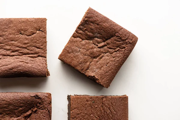 Vista dall'alto di deliziosi pezzi brownie su sfondo bianco — Foto stock