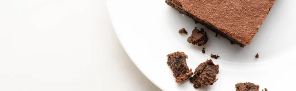 Vista superior de deliciosa peça de brownie na placa no fundo branco — Fotografia de Stock