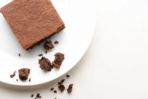 Vista superior de deliciosa peça de brownie na placa no fundo branco — Fotografia de Stock