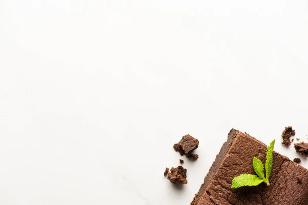 Vue du dessus de délicieux morceau de brownie avec menthe sur fond blanc — Photo de stock