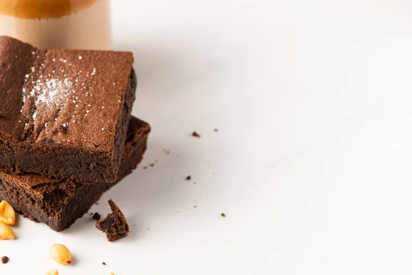 Deliciosos pedaços de brownie com amendoins no fundo branco — Fotografia de Stock