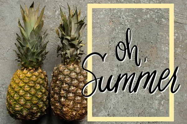 Top view of ripe pineapples on grey concrete surface with oh summer illustration — Stock Photo