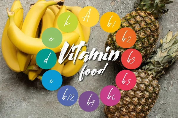 Top view of colorful delicious bananas and pineapples on grey concrete surface, vitamin food illustration — Stock Photo