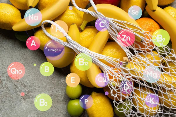 Vista dall'alto di frutta colorata e sacchetto di spago sulla superficie di cemento grigio, illustrazione vitamine — Foto stock