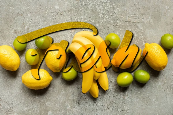 Top view of colorful bananas, limes and lemons on grey concrete surface, fresh illustration — Stock Photo